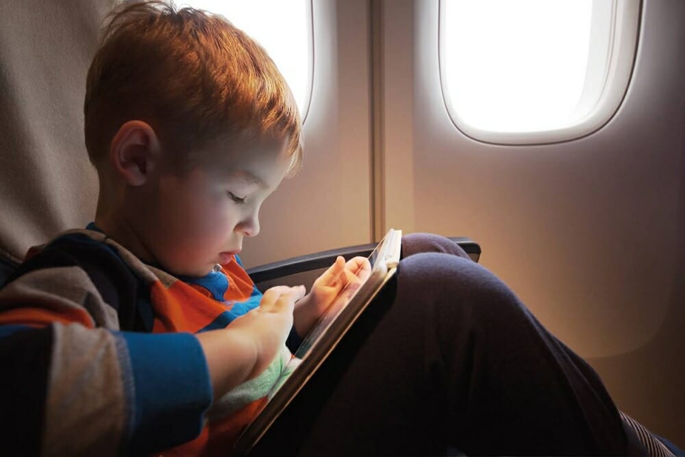 Little child with tablet computer in plane shutterstock
